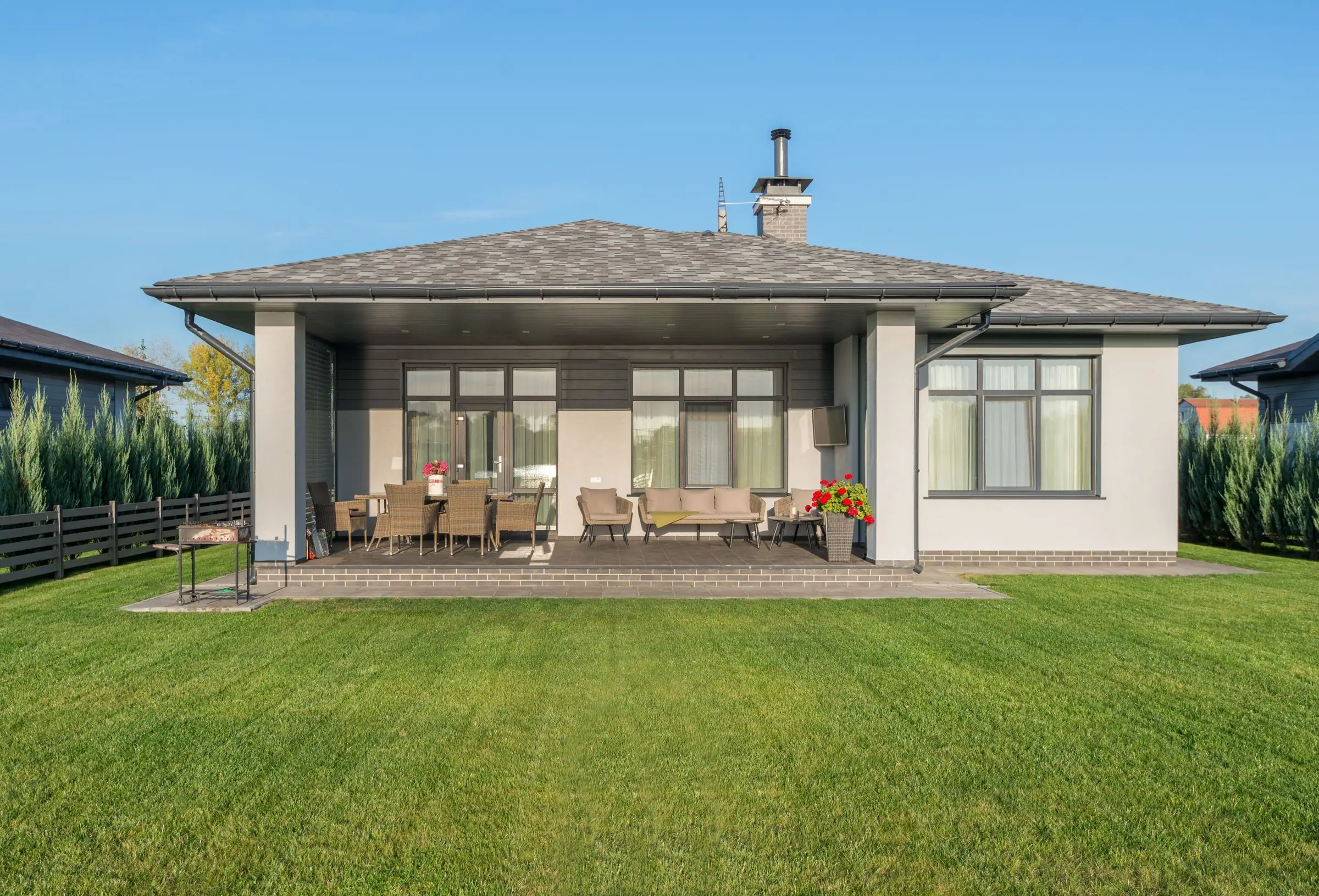 Covered back patio opening onto a wide green lawn